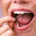 Boca de una mujer utilizando el hilo dental